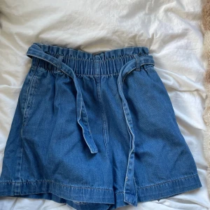 Jeansshorts  - Lite längre jeansshorts med band i midjan.