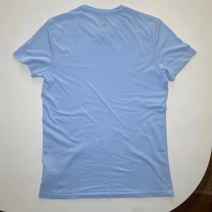 Ljusblå t-shirt från Polo Ralph Lauren - Säljer då den blivit för liten. Inga fläckar eller defekter hör av er om ni har några frågor. Jag på bilden är 189 så     Passar 175–180.