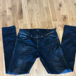 Svarta tramarossa jeans - Svara tramarossa jeans i w33 med skit snygga slitningar. Byxorna är gjorda i Italien och har sjukt snygga detaljer på insida och utsida! Kom med frågor!