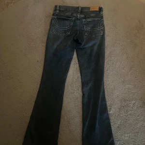 Blå bootcut jeans från Perfect Jeans - Snygga blå bootcut jeans från Perfect Jeans med coola kontrastsömmar på bakfickorna. Klassisk femficksmodell med dragkedja och knapp framtill. Jeansen har en lätt tvättad look och är tillverkade i mjukt denimtyg.