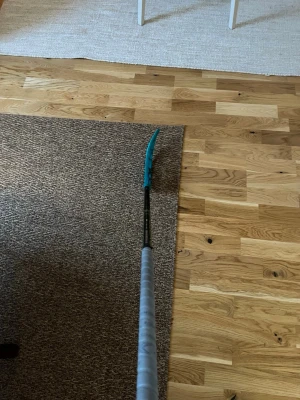 Innebandyklubba Oxdog Hyperlight - Säljer en Oxdog Hyperlight HES 27 innebandyklubba med svart och grått skaft, gröna detaljer och ett turkost blad. Klubban är lätt och har ett greppvänligt handtag, perfekt för dig som vill ha snabb bollkontroll och snygg design på planen.