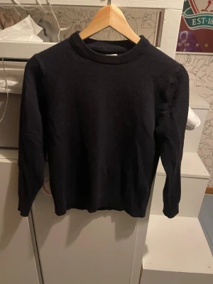 Svart merinoullströja These Glory Days - Snygg svart tröja från These Glory Days i mjuk och exklusiv merinoull. Klassisk rund hals och långärmad modell med ribbade muddar. Perfekt för dig som gillar stilrena och tidlösa plagg. Passar dig som vill ha en enkel men ändå lyxig look. Ett litet hål på ena armen. Skriv vid minsta fundering. Pris kan diskuteras 