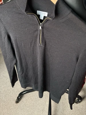 Svart cashmere halfzip från Sunspel - Svart långärmad tröja från Sunspel i storlek S, med stilren half zip-dragkedja framtill och ribbad krage. Tröjan är tillverkad i mjuk bomull och har en klassisk, normal passform. Perfekt för dig som gillar minimalistisk och clean stil. Ny pris 4200kr