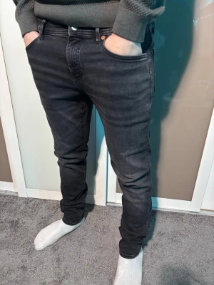 Grå svarta jeans från hugo BOSS - Säljer ett par svarta boss jeans med slim fit och klassisk femficksdesign. Jeansen har en snygg mörk tvätt, normal passform och är tillverkade i mjukt jeansmaterial. Perfekt för dig som gillar stilrena och bekväma jeans med modern look.