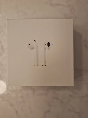 Helt Nya Apple Airpods 2nd Generation  - Helt nya Apple AirPods 2nd Generation, aldrig använda och i originalförpackning. Perfekta för musik, samtal och vardagsbruk med smidig anslutning till iPhone och andra Apple-enheter. Levereras med laddningsetui och tillbehör. Pris: 700 kr. Finns i Kristinehamn, kan skickas om köparen står för frakt.