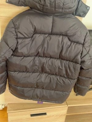 Svart pufferjacka från Polo Ralph Lauren - Svart pufferjacka från Polo Ralph Lauren med röd logga på bröstet. Jackan har huva, tre dragkedjefickor fram och quiltad design. Perfekt för kalla dagar och har en clean look som funkar till många stilar. KAN DUSKITERAS OM PRIS