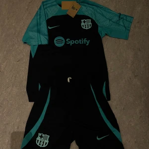 Ingen sko syns på bilderna - FC Barcelona fotbollsställ från Nike med tröja och shorts i svart och turkos, aldrig använda bara testade. Kom gärna med pris förslag!