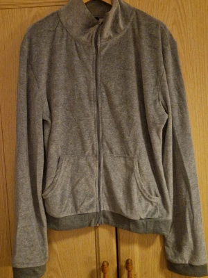 Plysch cardigan - En grå cardigan i plysch med dragkedja, märkt stl L/XL men uppskattar den mer som en M. Inte mkt använd. Kolla gärna in mina andra annonser! 