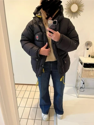 Svart dunjacka från Fjällräven XXXS - Svart dunjacka med luva från Fjällräven säljes då jag köpte för liten. Storleken är XXXS men den passar som en XS. Gott skick, inga hål eller andra defekter. 