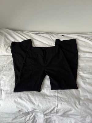 Svarta kostymbyxor från Gina Tricot - Assnygga svarta kostymbyxor från Gina Tricot i storlek 34. Super sköna och passar till allt!!!