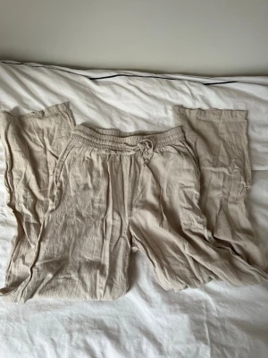 Beiga linnebyxor från Vero Moda XS - Säljer ett par beiga linnebyxor från Vero Moda i storlek XS (men passar även S och m) . Byxorna har elastisk midja med snörning och raka, lite bredare ben. 
