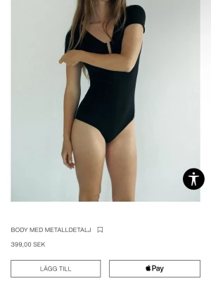 Svart body med metallring XS-S - Säljer en svart body i storlek XS-S. Bodyn har korta ärmar, en snygg v-ringning och en metallring som detalj framtill. Skit snygg och säljer endast för jag har en likadan 