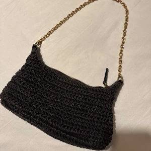 Svart handväska med guldkedja - Säljer denna svart handväska i virkat material med guldfärgad kedjerem. I fint skick! 💕