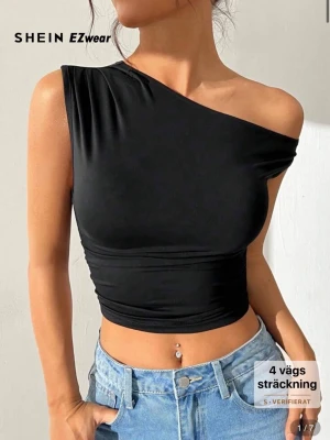 Svart oneshoulder croppad topp från SHEIN - Säljer en svart, croppad topp från SHEIN med oneshoulder-design. Den är stretchig och helt ny!🤍🥰