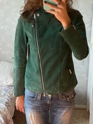 Grön Dry Lake bikerjacka Vintage - En så himla fin och cool bikerjacka från märket Dry Lake som tyvärr är lite för liten. Storlek S men aningen kort i ärmarna. Skriv om ni vill ha exakta mått 💕Materialet är mocka!