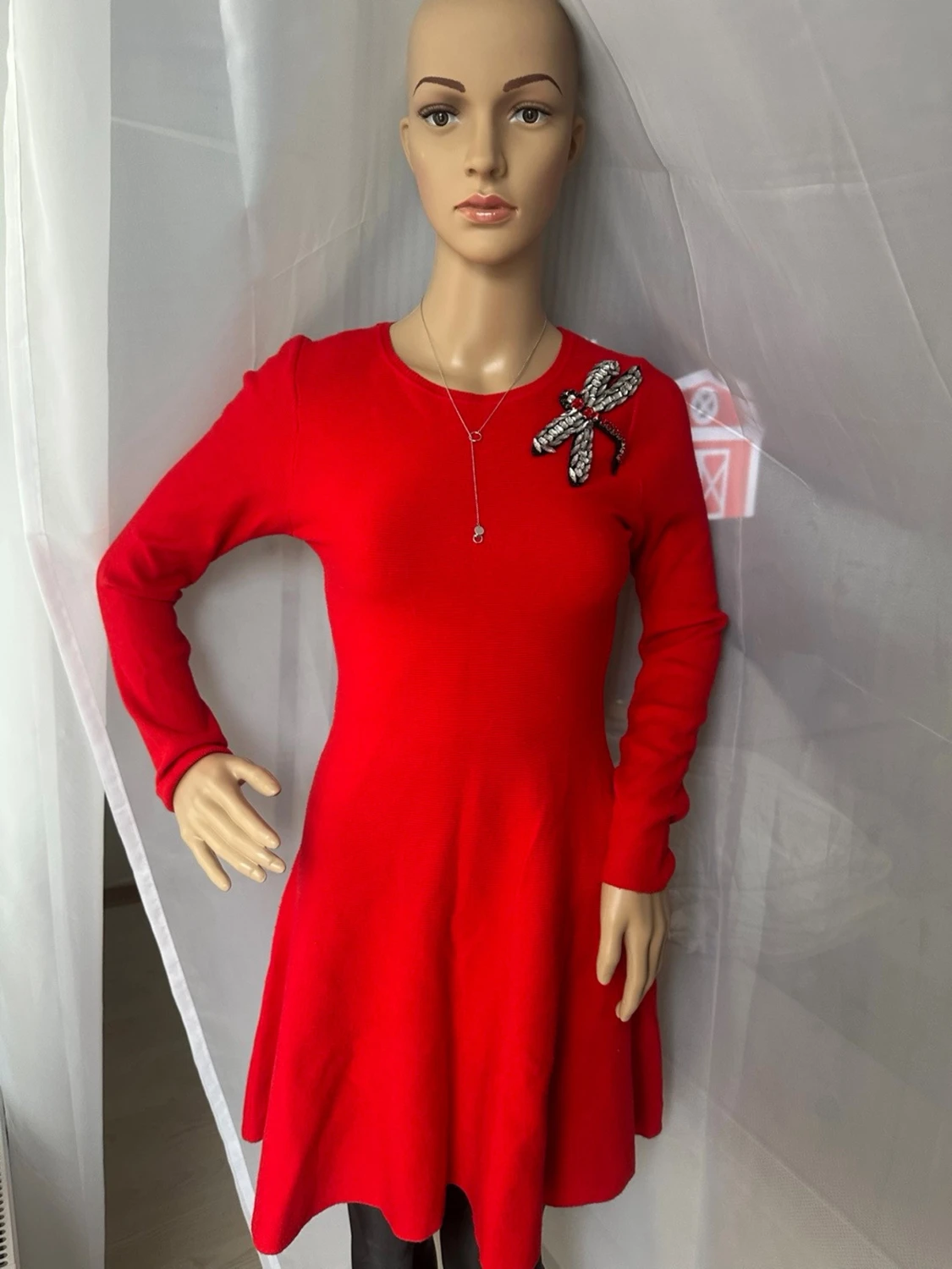 Röd stickad klänning med brosch