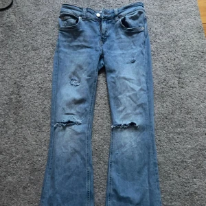Blå bootcut jeans med slitningar - Snygga blå jeans med bootcut passform och slitna detaljer! 