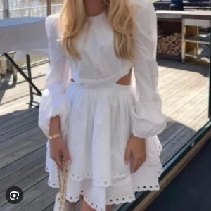 Studentklänning  - Säljer min otroliga studentklänning! En helt perfekt vit klänning med ballongärmar, cut-outs på sidorna och öppen rygg. 