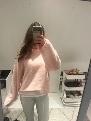 Ljusrosa stickad tröja Gina Tricot - Supermysig ljusrosa stickad tröja från Gina Tricot i ullblandning. Tröjan har rund hals, ribbade muddar och långa ärmar med lite loose passform. Perfekt för kyliga dagar när du vill vara både comfy och snygg.