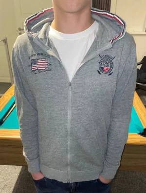 Grå Zip Hoodie - En riktigt snygg grå zip hoodie i storlek 12y! Köpte av någon som sa att det var xs men var inte det så inte mina bilder, passar någon från 155-165 skulle jag säga men inte helt säker, skulle nog vara xxs i herr storlek😁👍Skriv för frågor, fler bilder osv👌🏼