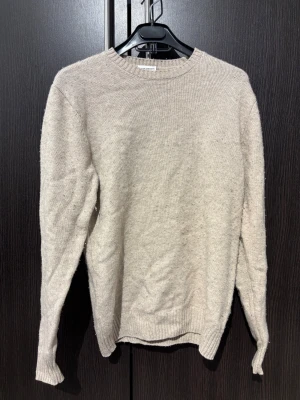 Beige stickad tröja från John Henric - Säljer en stickad tröja i 90% ull 10% kamsir den är i storlek S. tröjan är lite nopprig men orkar man ta bort den är den så gott som ny.