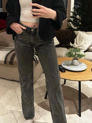 Svarta straight jeans  - Säljer ett par svarta jeans med klassisk femficksdesign och raka ben. Jeansen har låg midja och är tillverkade i slitstarkt denim. 