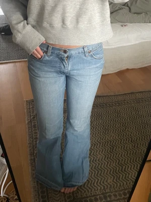 Bootcut ljusblå jeans med snakeprint - Säljer ett par ljusblå bootcut jeans. På bakfickan finns en blå snakeprint som ger snygg vintagekänsla. Midja 38 innerbenslängd 80. Kan posta idag vid snabb affär!
