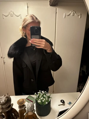 Svart pälsjacka från Meotine XS/S - Säljer en svart pälsjacka från Meotine i storlek XS/S.  Passar mig som bär S!Jackan har en bred, fluffig fuskpäls-krage och stora fickor framtill. Den är kortare i modellen och har knappar som stängning. Perfekt för dig som vill ha en statement-jacka i höst och vinter. Hör av dig vid frågor eller vill diskutera priset💋💋