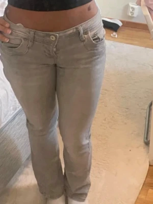 Grå LTB jeans  - Säljer ett par ljusgrå bootcut jeans från LTB med klassisk femficksdesign och låg midja. Jeansen har raka ben med lätt utsvängning nertill och är tillverkade i mjukt denimtyg. Perfekta för en avslappnad och trendig look. Storlek: w26/l32 (s) 