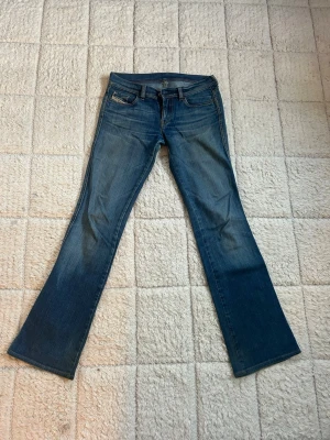 Blå bootcut jeans - Snygga blå jeans med klassisk bootcut-passform. Jeansen har en mörkblå tvätt med lätt slitning och raka ben som breddas nedtill. Perfekt i längd på mig som är runt 170cm.
