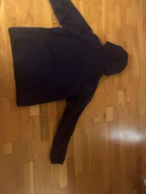 Mörkblå hoodie Nike tech - Säljer en mörkblå tröja från  från nike med huva och lång ärm. Hoodien  har en diskret dragkedja och en ficka på ärmen. Perfekt för dig som gillar att vara ute och vill ha en stilren look.