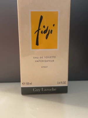 Fidji Eau de Toilette Spray - Oöppnad! Fidji Eau de Toilette från Guy Laroche, 100 ml spray. En klassisk parfym från Paris, perfekt för dig som vill sticka ut med en ikonisk doft i snygg förpackning.