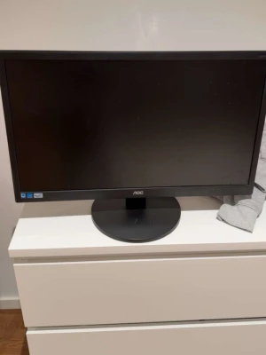 AOC skärm/monitor - AOC E2470SWDA 24-tums LED-skärm i svart. Skärmen har Full HD-upplösning och är i gott skick med mindre yttre slitage på baksidan. Perfekt för både arbete och spel. Alla anslutningar och etiketter är tydliga och synliga.