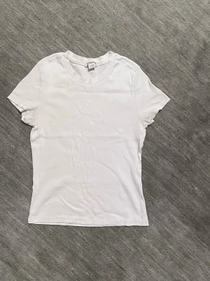 Vit ribbad T-Shirt - Säljer nu denna vita ribbade T-Shirten från Monki i bomull och storlek S. T-Shirten är i bra kvalitet och känns inte sliten alls. 