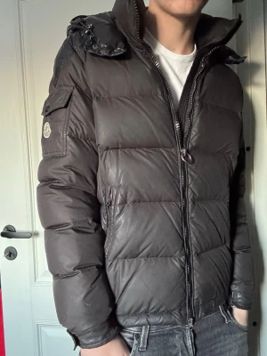 Moncler jacka - Säljer denna galet feta jacka från Moncler! Skick 7/10 - har en del defekter (små fläckar, revor, osv) men fint skick i sin helhet! Nypris 20 500kr, mitt pris endast 2599kr (STEAL). Modellen heter "Chevalier" och är mycket eftertraktad. Storlek 3, passar M (killen på bilden är 186 cm). Hör av er vid funderingar!