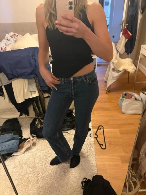 Blå jeans från Perfect Jeans, storlek 34 - Säljer ett par klassiska blå jeans från Perfect Jeans i storlek 34. Modellen har rak passform med låg midja och är tillverkad i slitstarkt denimtyg. Perfekt för dig som gillar en enkel och tidlös look. Jeansens färg är mörkblå och de har traditionella fickor och knappgylf.