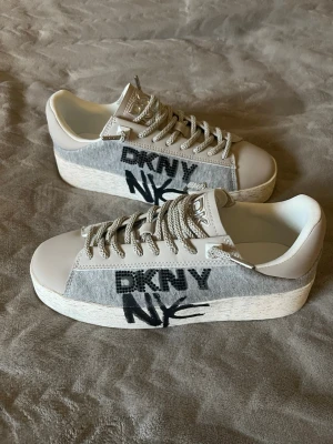 DKNY Ginali Graffiti sneakers - Snygga DKNY Ginali Graffiti sneakers. Helt oanvända och går inte att köpa längre. Extra stenar medföljer för dekoration. Skriv för frågor! Kan även diskutera pris!! 💓