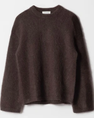 Brun stickad tröja från & Other Stories - Mjuk och fluffig brun stickad tröja från & Other Stories med rund hals och lång ärm. Tröjan har en loose passform och är perfekt att slänga på sig när det är kyligt ute. Materialet känns lyxigt och ger en skön känsla mot huden.