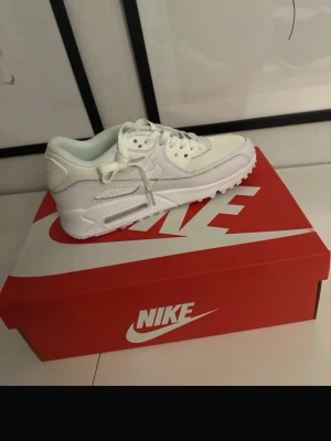Vita Nike Air Max sneakers 39  - Säljer ett par fräscha vita Nike Air Max sneakers med klassisk siluett och snygga detaljer. Skorna har snörning, rund tå och en chunky sula som ger grym komfort. Perfekta till streetwear eller casual outfits. Kommer i originalkartong.