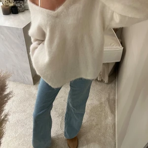 Vit stickad tröja från H&M Edition - Supermysig vit stickad tröja från H&M Edition med v-ringad hals och lång ärm. Tröjan har en loose passform och är lite fluffig i materialet, perfekt för chill dagar. Sitter snyggt offshoulder och är lätt att styla med jeans eller kjol. Köpt för original priset!! 