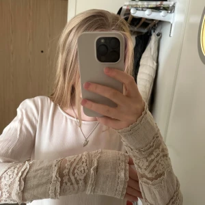 Vit blus med spetsdetaljer Vero Moda - Supersöt vit blus från Vero Moda med långa ärmar och spetsdetaljer på ärmarna. 