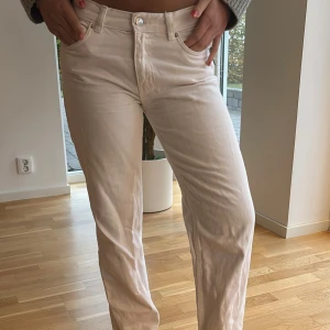 Beiga raka jeansbyxor - Säljer ett par snygga beiga jeansbyxor med rak passform och klassisk femficksdesign. Byxorna har normal midja och är tillverkade i mjuk bomull, perfekta för en chill och stilren look.