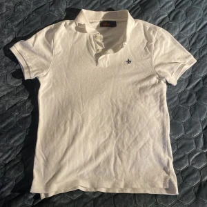 Morris pike - Vit pikétröja från Morris med klassisk krage och knappar framtill. Tröjan har en liten broderad logga på bröstet och är gjord i mjuk bomull. Perfekt för en clean och stilren look. Inga tecken på användning nästan👍