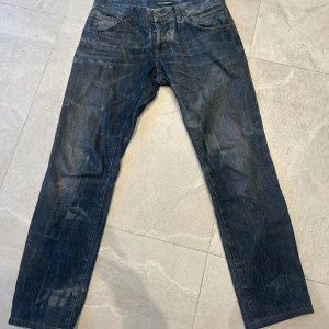 Dolce & Gabbana jeans straight fit - Snygga blå jeans från Dolce & Gabbana med klassisk femficksdesign och raka ben. Jeansen har en mörk tvätt med slitningar och detaljer som metallmärke bak och logoknapp fram. Tillverkade i bomull för en skön känsla och stilren look.