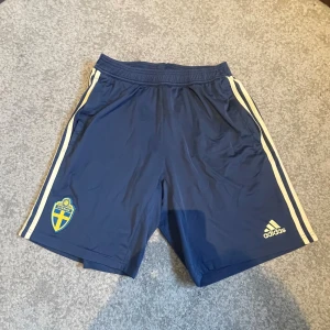 Adidas shorts Sverige  - Tja! Säljer dessa Mörkblå landslagsshorts från Adidas, dessa är spelare i landslaget som använder och går ej att köpa så dom är väldigt limiterade i mängden! Storlek L Passar M