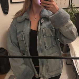 Jeansjacka med päls - Ljusblå jeansjacka med mjuk teddykrage och teddy på ärmsluten. Jackan har stora fickor framtill och stängs med dragkedja. Går att vika upp och ner ärmarna🩵Jättefint skick!