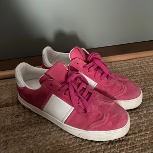 Valentino Garavani rosa sneakers - Snygga sneakers från Valentino Garavani i rosa mocka och vitt skinn. Skorna har klassisk snörning, vit sula och coola silverfärgade nitar på hälen. Kan diskutera priset vid snabb affär!🌸🩷
