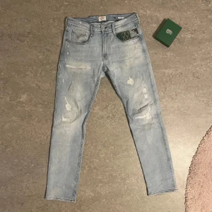 Ljusblå Replay jeans med slitningar - Säljer ett par ljusblå jeans från Replay med snygga slitningar och distressed detaljer. W31 L32