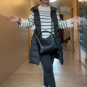 JDY  lång väst med huva Stl XS  - Säljer en svart, quiltad lång väst med huva. Västen har en rak passform och går ner till knäna. Perfekt att slänga över en hoodie eller stickad tröja för extra värme. Stängs med dragkedja framtill och har praktiska fickor på sidorna. Anvönd Max 3 gng.