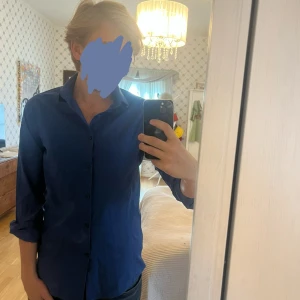 Blå skjorta från Burton Menswear - Snygg blå skjorta från Burton Menswear London i skinny fit. Skjortan har klassisk krage, knäppning framtill och långa ärmar. Materialet är mjukt och lättskött bomull, perfekt för en clean och stilren look. Passar M 